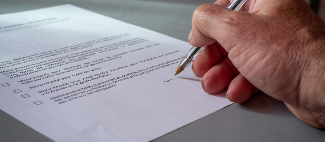 close up of a Man signing  french authorization to go out side, concept quarantine in France.