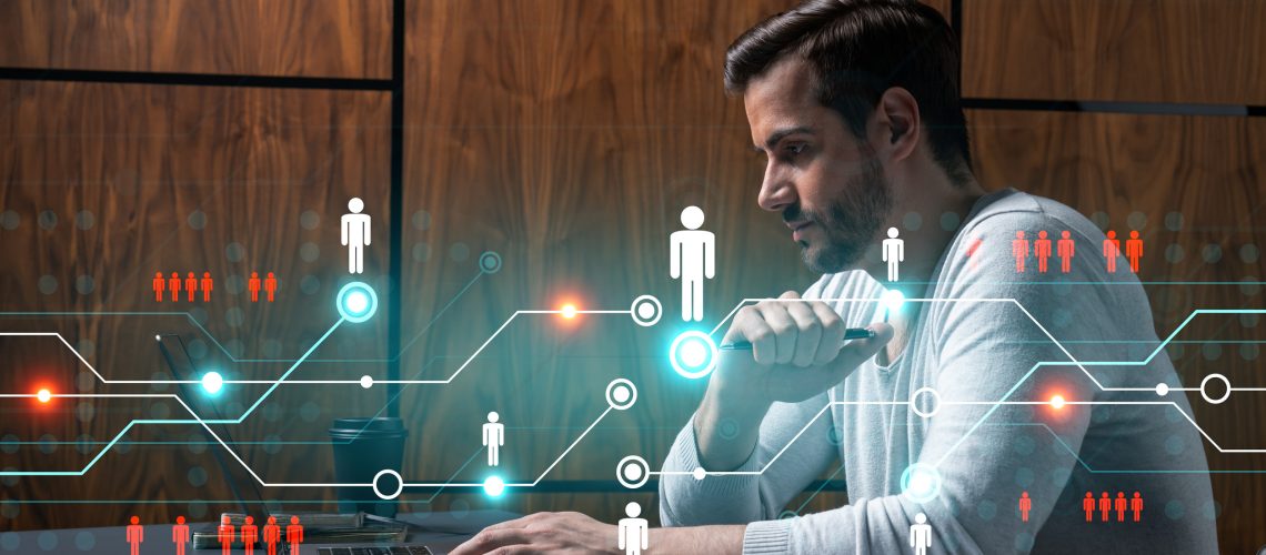 A serious caucasian manager in casual wears, using laptop to develop a new network. Double exposure. Social media hologram.