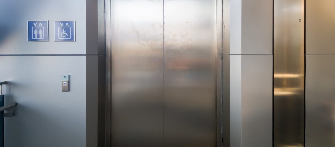 The new passenger elevator with the usage symbol for service in the suburban train train station, front view with the copy space.