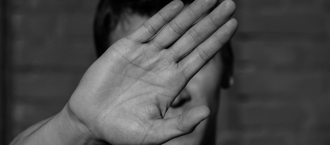 a young man covers his face with hand